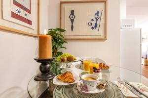 a glass table with a candle and a cup of coffee at La petite maison de Nadette in Gandía