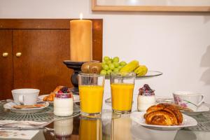 a table topped with glasses of orange juice and pastries at La petite maison de Nadette in Gandía +72 photos