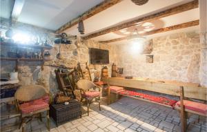 a room with chairs and a stone wall at Seven-Bedroom Holiday Home In Dicmo in Osoje