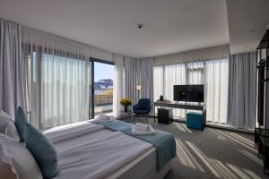 a bedroom with a large bed and a large window at Bizarre Boutique Hotel in Varna City