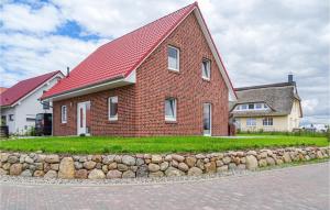 a brick house with a red roof and a stone wall at Beautiful Home In Groß Schwansee in Groß Schwansee