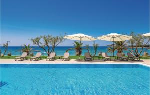 a pool with chairs and umbrellas next to the ocean at Nice Apartment In Povljana in Povljana