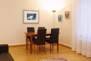 a dining room with a wooden table and black chairs at 1BR apartment close to Opera - SF7 in Zürich