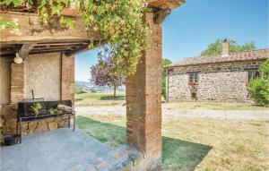 ein Backsteinpfeiler mit einer Bank vor einem Gebäude in der Unterkunft Cozy Home In Sarteano -Si- With Kitchen in Castiglioncello del Trinoro