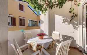 a table and chairs sitting on a patio at 2 Bedroom Nice Apartment In Mali Losinj in Mali Lošinj