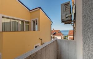 a view from the balcony of a yellow building at 2 Bedroom Nice Apartment In Mali Losinj in Mali Lošinj +14 photos