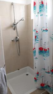 a bathroom with a shower with a shower curtain at Pereybère Apartment in Pereybere