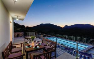 a balcony with a table and chairs next to a pool at Gorgeous Home In Zaton Veliki in Zaton