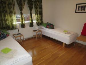 a living room with two white beds and a window at Teigur Guesthouse in Akranes