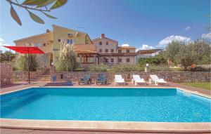 ein Pool mit Stühlen und ein Haus im Hintergrund in der Unterkunft 4 Bedroom Amazing Home In Pavicini in Veliki Vareški