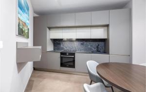 a kitchen with white cabinets and a wooden table at Nice Home In Labin With Wifi in Labin