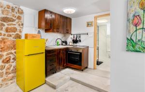 a kitchen with a yellow refrigerator and wooden cabinets at 3 Bedroom Nice Home In Karlobag in Karlobag