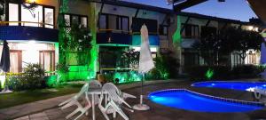 un hotel con piscina, sedie e ombrellone di Fantástica Casa 02 Quartos nas belas praias do Flamengo a Salvador