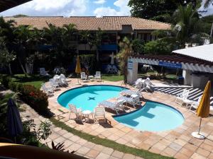 una piscina con sedie e ombrelloni in un resort di Fantástica Casa 02 Quartos nas belas praias do Flamengo a Salvador Altre 52 foto