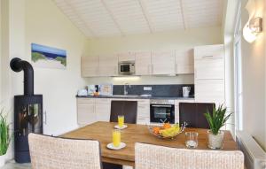 a kitchen with a wooden table with a bowl of fruit on it at Beautiful Home In Dagebüll With Sauna in Dagebüll