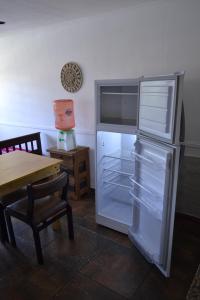 a refrigerator with its door open next to a table at Casa San Clemente del Tuyú in San Clemente del Tuyú