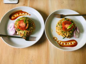 two plates of food with a sandwich and a hot dog at Container Villa Luxury Collection in Weliweriya