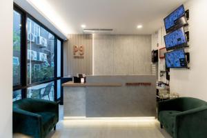 a lobby with two green chairs and a reception counter at P9 Ratchada Hotel in Bangkok