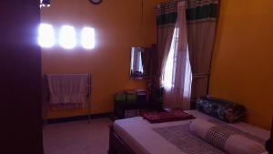 a bedroom with a bed and a window and a mirror at Permana Dewi Homestay in Panjalu