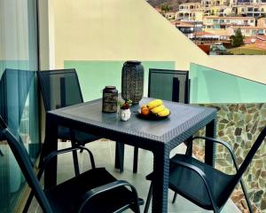 Una mesa negra con fruta encima de un balcón. en Casa Tucan - two bedrooms, heated pool, city and ocean views, en Patalavaca