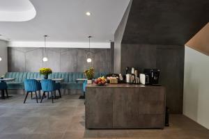 a dining room with a counter and blue chairs at Bizarre Boutique Hotel in Varna City