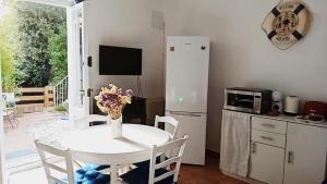 a kitchen with a white table and a white refrigerator at La vinya in Sant Feliu de Guixols