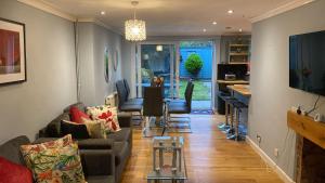 a living room with a couch and a table at Warm and Homely 4 Bed house w big Garden & Parking in Milton