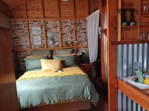 Un dormitorio con una cama en una habitación de madera. en Owl's Den 1, en Oudtshoorn