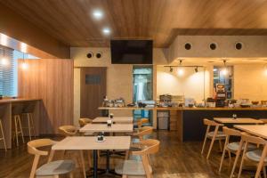 福岡市にある南福岡グリーンホテル-Minami Fukuoka Green Hotelのテーブルと椅子とバーのあるレストラン
