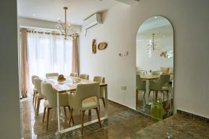a dining room with a table and chairs and a mirror at The Retreat Minimum 3 Nights in Dehiwala