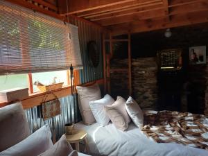 Un dormitorio con una cama con almohadas blancas y una ventana en Owl's Den 1, en Oudtshoorn