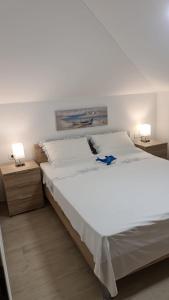 a large white bed in a bedroom with two lamps at Apartment Anton in Selce