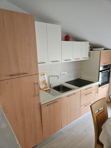 a kitchen with white cabinets and a sink at Apartment Anton in Selce