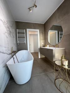 ein Badezimmer mit einer großen Badewanne und einem Spiegel in der Unterkunft Apartament Bucuresti Nord in Bukarest + 33 Fotos