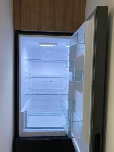 an empty refrigerator with its door open in a room at Porcelain Apartment in Rădăuţi
