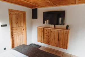 a bedroom with a flat screen tv on a wall at Zasebna hiša v naravi s savno, hiša 14H in Laško