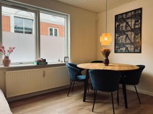 a dining room with a table and chairs and a window at Cozy Flats Silkeborg - S2 in Silkeborg