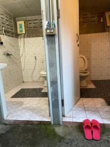 two red slippers in a bathroom with a toilet at YPHomestay in Pai