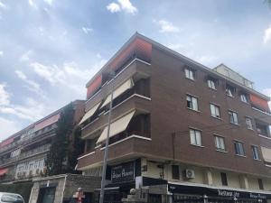 a tall brick building on the corner of a street at Hostal El Pozarron in Las Rozas de Madrid