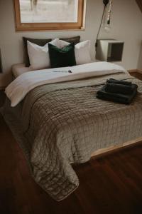 a bed with a bag sitting on top of it at Zielony domek nad jeziorem Mazurskie klimaty in Pogubie Tylne +81 photos