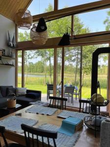 a living room with a table and chairs and a large window at Zielony domek nad jeziorem Mazurskie klimaty in Pogubie Tylne