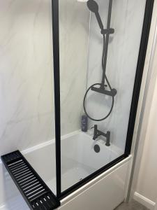 a shower with a bath tub with a shower head at Castle View Apartments - The Hideout in Kendal +33 photos