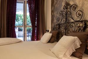 a bedroom with a large white bed with a metal headboard at Fiordiloto B&B 4 STARS in Alba +17 photos