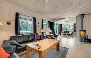 a living room with a leather couch and a table at Pet Friendly Home In Vejers Strand in Vejers Strand