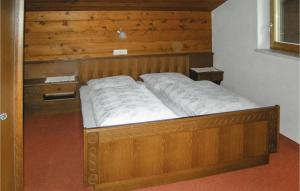 łóżko w pokoju z drewnianym zagłówkiem w obiekcie Ansprechende Ferienwohnung w mieście Brixlegg +5 zdjęć