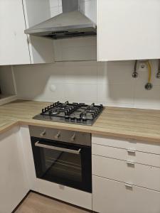 een keuken met een kookplaat en witte kasten bij Lagoon House in Santiago do Cacém