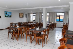 a dining room with wooden tables and chairs at Inter Hotel in Vitória