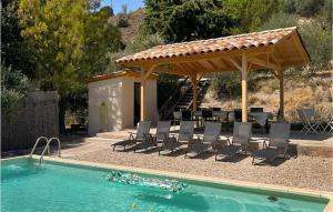 einen Pool mit Stühlen und einen Pavillon neben einem Pool in der Unterkunft 3 Bedroom Cozy Home In Mormoiron in Mormoiron + 19 Fotos