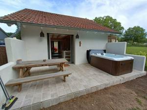eine Terrasse mit einem Picknicktisch und einem Whirlpool in der Unterkunft La casita, maison individuelle avec jacuzzi in Falck