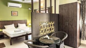 a room with a bed and a table and chairs at The Majorda Pristinne Hotel in Majorda +10 photos